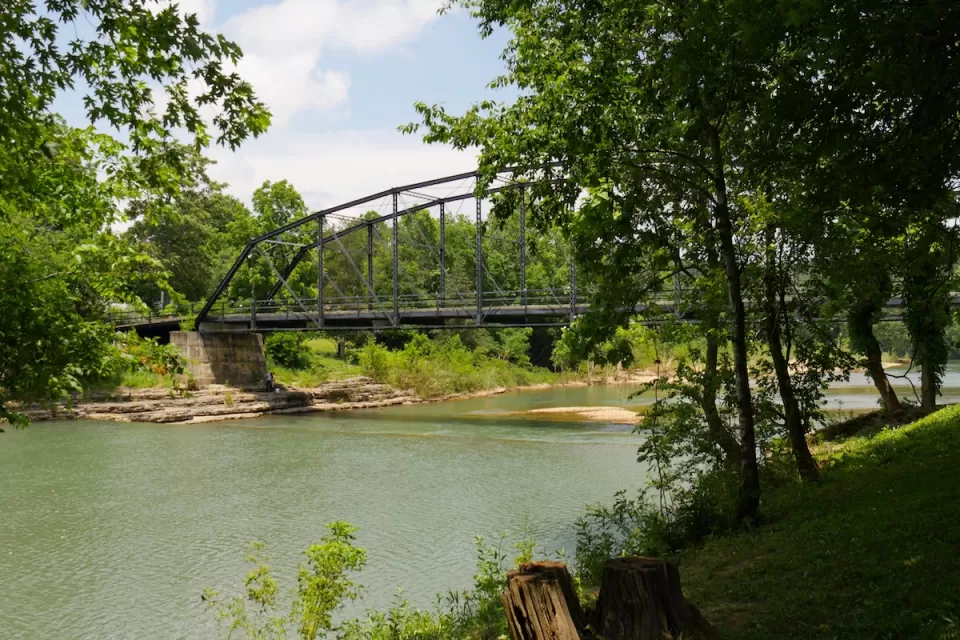 Old wooden bridge with steel railings at the War Eagle River in Rogers, Arkansas.